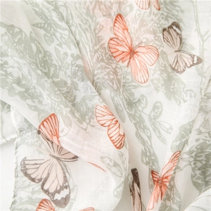 Macro view of semi-transparent scarf fabric with floral and butterfly patterns