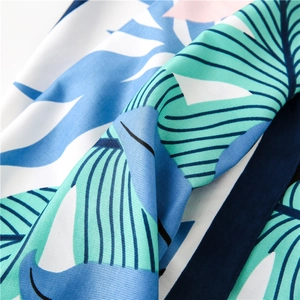 Detailed macro view of tropical plant leaf print on silk scarf with twill texture