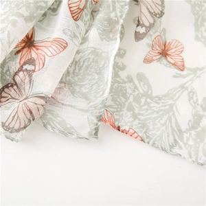 Macro shot of breathable linen-feel scarf fabric with butterfly and floral prints