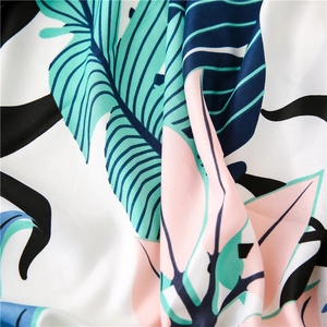 Detail of tropical palm leaf pattern on smooth beach shawl fabric with soft texture