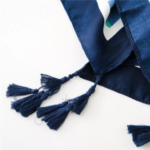 Detail of dark blue beach shawl featuring white geometric prints and tassel fringe edge