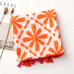 Detail of white scarf with orange floral pattern and vibrant pink fringe tassels