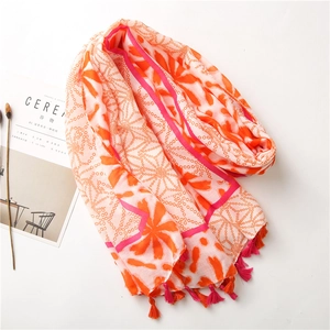 Detail of floral patterns and fringe tassels on a lightweight cotton linen scarf