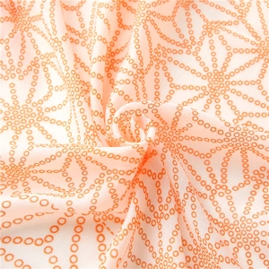 Detail of soft lightweight scarf fabric featuring orange geometric star patterns