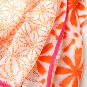 Detailed texture of lightweight floral and polka dot shawl with fine pink stitched edges