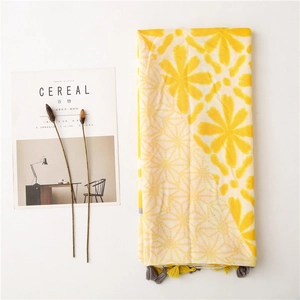 Detail of floral print scarf with yellow blossoms, polka dots and fringe edges