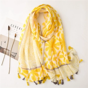 Detail of yellow floral cotton shawl with tassels and artistic magazine background