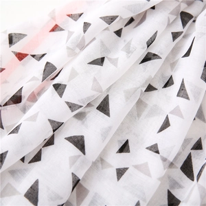 Macro shot of lightweight white scarf featuring black and grey geometric triangle patterns