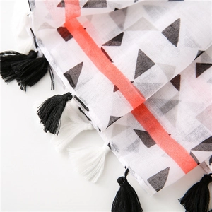 Close-up of geometric triangle pattern and fringe detail on a lightweight scarf