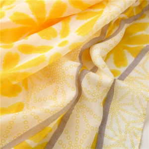 Close-up of lightweight floral scarf showing yellow petal prints and soft fabric texture