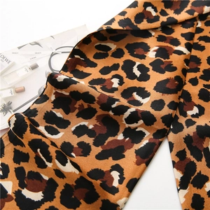 Détail d'un foulard en soie à imprimé léopard avec une texture satinée lisse