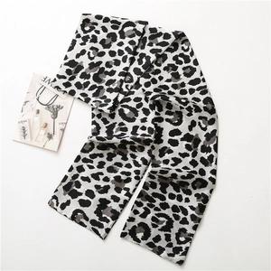 Petit foulard en satin imprimé léopard noir et blanc, élégamment posé pour accessoire mode