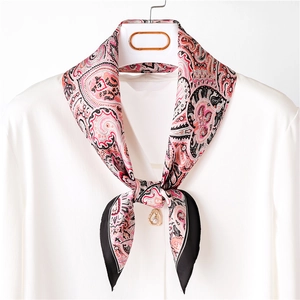 Red paisley pattern silk scarf with black border styled on a white shirt collar