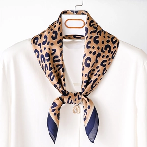 Close-up of leopard print silk scarf tied on a white shirt collar for business styling