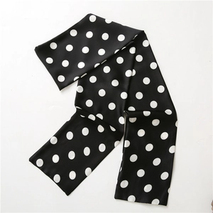 Detail of a silky black necktie scarf with white polka dots for suit accessories