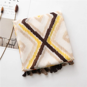 Detail of colorful bohemian scarf with geometric patterns and long decorative fringe