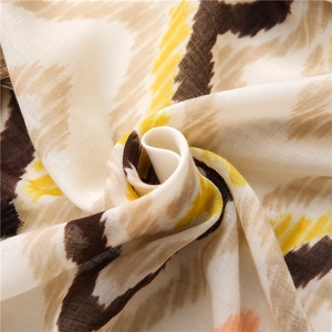 Macro view of bohemian ikat pattern on lightweight cotton linen scarf with soft fringe