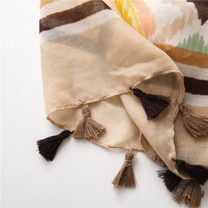 Detail of bohemian scarf showing colorful kaleidoscope patterns and decorative fringe tassels