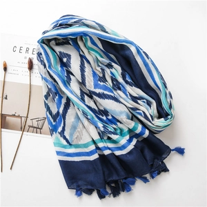 Detail shot of bohemian blue kaleidoscope scarf with chic tassel edges on white background