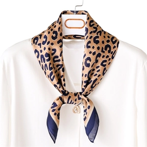 Elegant leopard print square scarf with gold heart pendant on white silk shirt