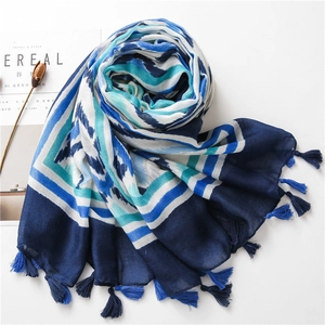Detail of blue geometric wave pattern on linen shawl with elegant fringe tassels