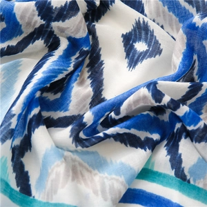 Macro detail of Bohemian cotton linen scarf featuring blue and white ikat print texture