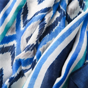 Macro detail of Bohemian style scarf showing blue geometric patterns and linen texture