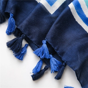 Detailed shot of bohemian scarf with blue geometric stripes and colorful tassels