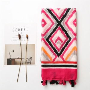 Detail of colorful geometric diamond pattern scarf with pink and black tassels
