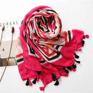 Macro shot of rose red bohemian scarf with geometric stripes and stylish fringe detail