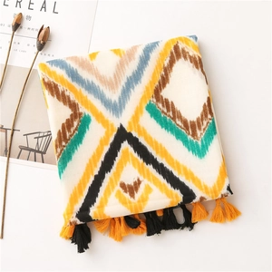 Detail of bohemian cotton linen scarf featuring colorful geometric patterns and tassels
