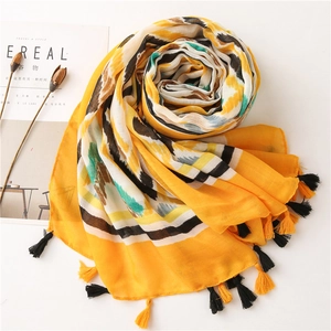 Close-up of bohemian yellow ikat pattern scarf with elegant fringe tassels and soft texture