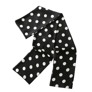 Elegant black and white polka dot silk scarf in a long rectangular shape on white background