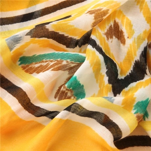 Detailed macro view of bohemian kaleidoscope patterns on breathable linen scarf fabric