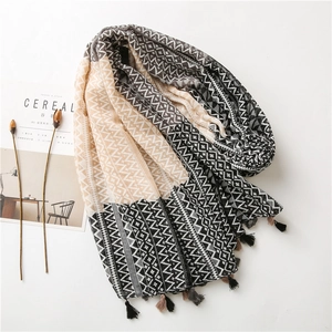 Detail of geometric print scarf with fringes, styled with magazine and dried flowers