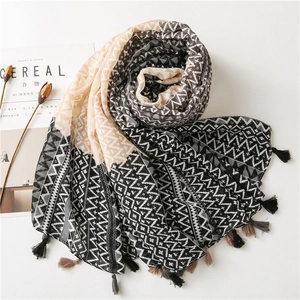Detailed view of lightweight shawl with black and beige geometric patterns and fringe