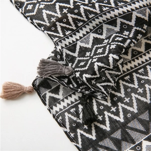 Close-up of geometric pattern silk scarf with tassels showing fabric texture and detail