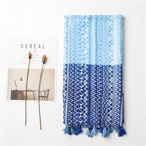 Detailed flat lay of blue geometric print scarf with bohemian patterns and tassels