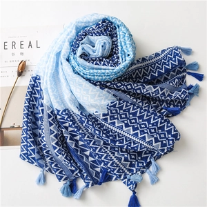 Detail of blue and white bohemian scarf with geometric patterns and tassel edges