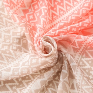 Artistic spiral fold of lightweight geometric pattern scarf with soft pastel texture