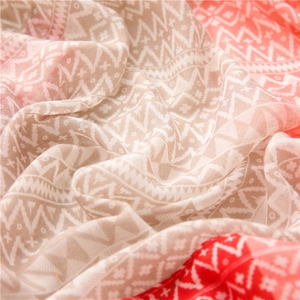 Close-up of geometric pattern scarf showing lightweight red and beige woven fabric detail