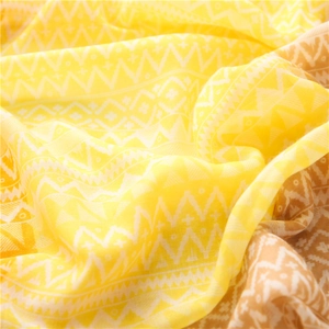 Detail of yellow Bohemian geometric scarf showing soft folds and sheer fabric texture