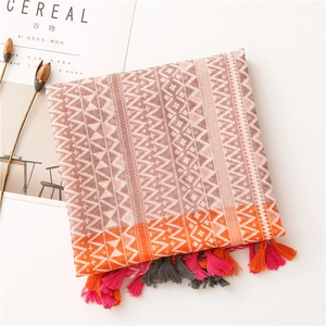 Detail of color-block geometric print scarf with decorative tassels on white background