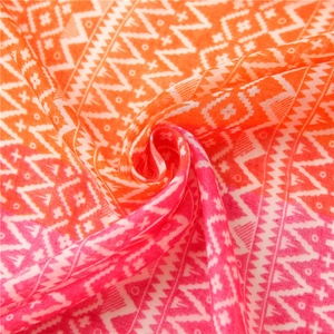 Detail of color-block cotton linen scarf with orange-pink gradient and geometric patterns