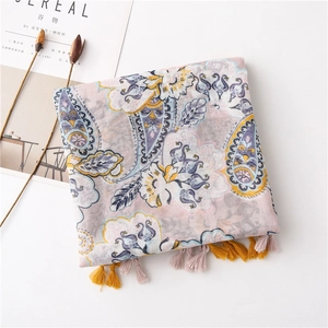 Detail of pink and purple paisley scarf with yellow fringe on minimalist background