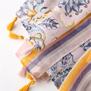 Detailed macro shot of printed scarves with bohemian patterns and fringe edges