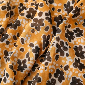 Vue détaillée d'une écharpe légère en coton avec imprimé floral jaune et pois blancs