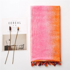 Detail of pink gradient cotton scarf featuring multi-color tassels and snowy texture