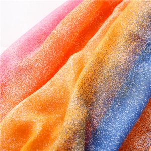 Macro shot of rainbow gradient scarf with fine white speckle texture and soft fabric folds