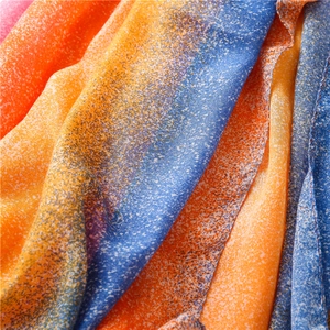 Macro shot of gradient orange and blue scarf fabric with fine white texture details
